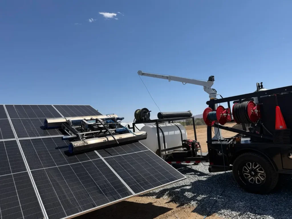 Professional solar panel cleaning equipment using a rotating brush system on ground-mounted solar panels