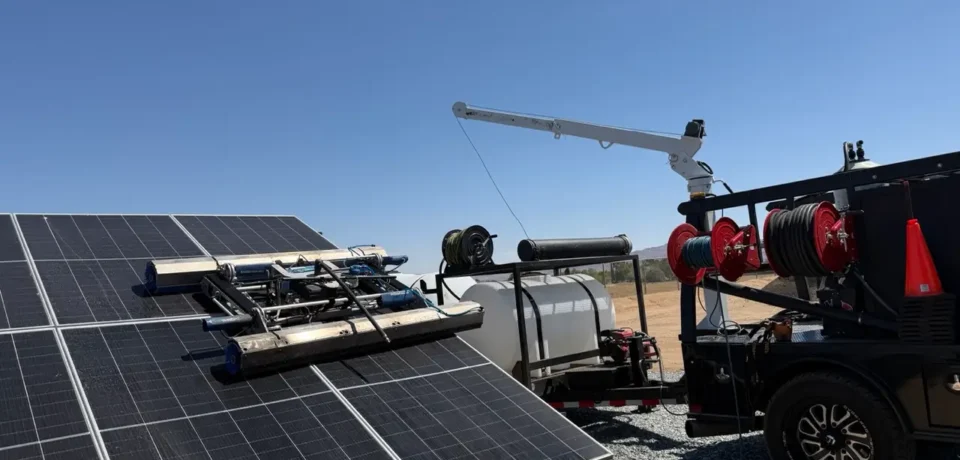 Professional solar panel cleaning equipment using a rotating brush system on ground-mounted solar panels